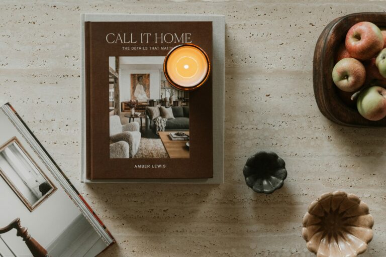 Book, candle, and apples on a table.